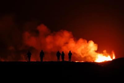 People watch as a volcano erupts in southwest Iceland. (Photo via Getty Images’ Facebook page.)